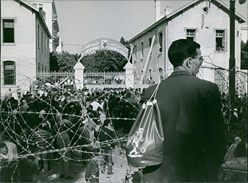 Гроздобер фотографија на човек со поглед на огромен собир на луѓе во Алжир, 1963 година.